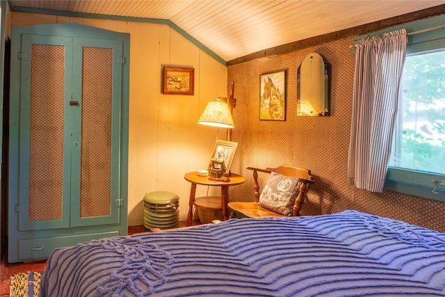 bedroom featuring lofted ceiling and wood walls