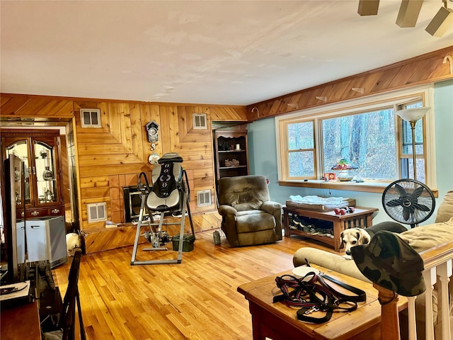 living room with wood walls and light hardwood / wood-style flooring