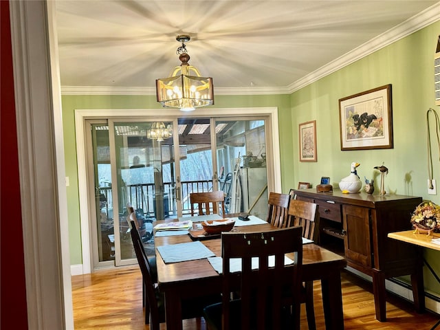dining room with crown molding, an inviting chandelier, and light wood-type flooring