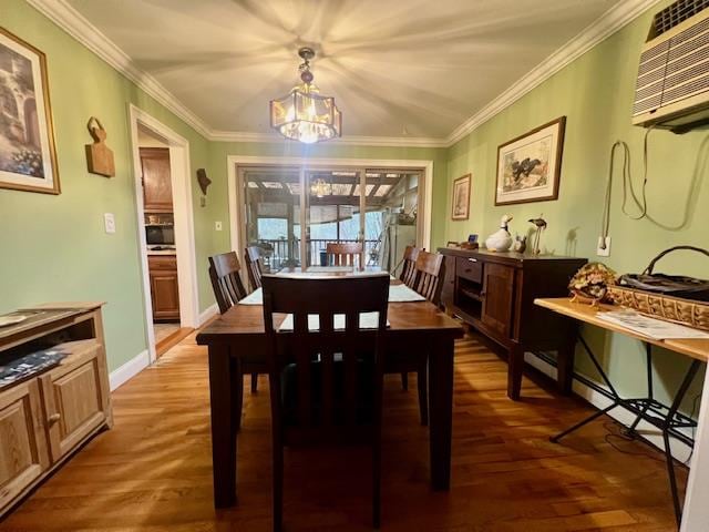 dining area with dark hardwood / wood-style floors, an AC wall unit, ornamental molding, and an inviting chandelier