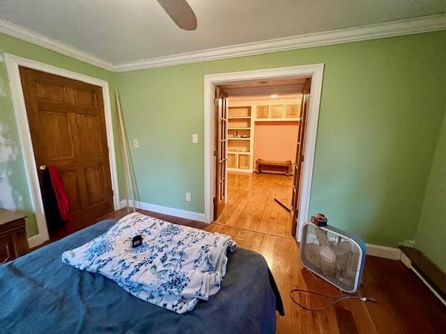 bedroom featuring ceiling fan, light wood-type flooring, and crown molding