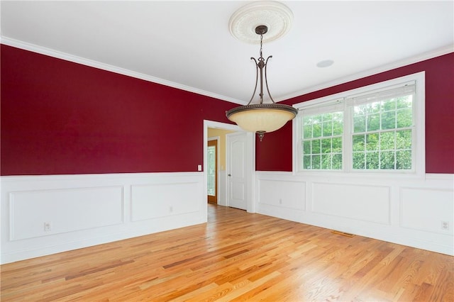 empty room featuring hardwood / wood-style flooring and crown molding