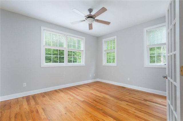 unfurnished room with a wealth of natural light, light hardwood / wood-style flooring, and ceiling fan