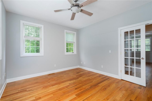 unfurnished room featuring ceiling fan, light wood-type flooring, and french doors