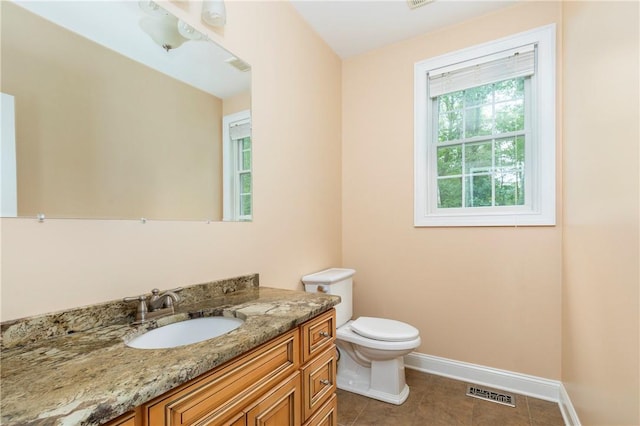 bathroom with tile patterned flooring, vanity, and toilet