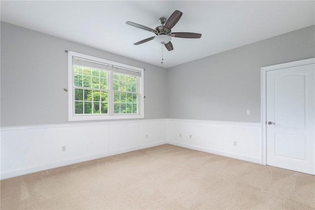 spare room featuring ceiling fan and light colored carpet