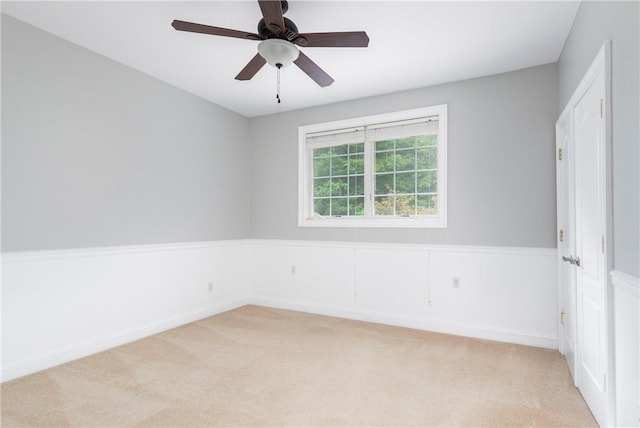 spare room featuring ceiling fan and light colored carpet