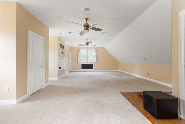 additional living space with ceiling fan, light colored carpet, and lofted ceiling