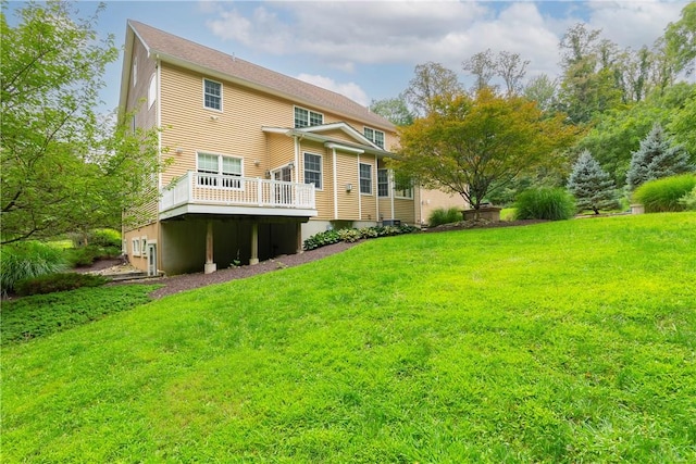 rear view of property with a deck and a lawn