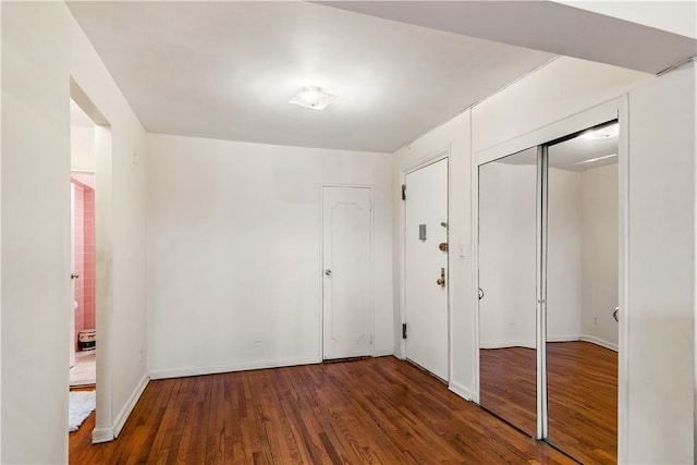 unfurnished bedroom with dark wood-type flooring