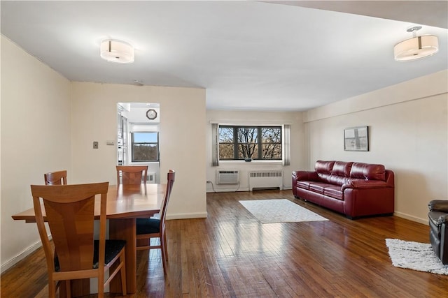 dining space with an AC wall unit, radiator, and dark wood-type flooring