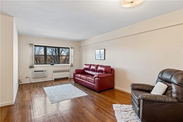 living room featuring hardwood / wood-style flooring, radiator heating unit, and a wall unit AC