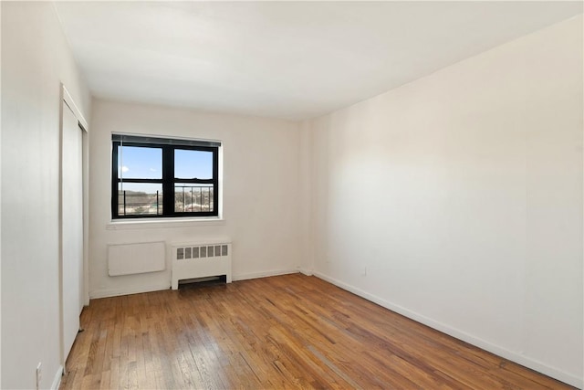 spare room with radiator and light wood-type flooring