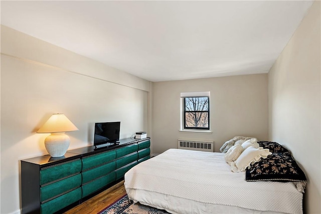 bedroom featuring hardwood / wood-style floors and radiator heating unit