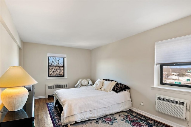 bedroom featuring radiator, a wall mounted AC, and hardwood / wood-style flooring