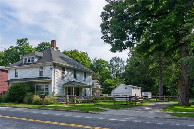 view of front facade featuring a garage and an outbuilding