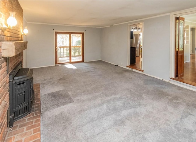 unfurnished living room with carpet, a wood stove, and crown molding