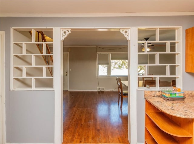 interior space featuring ceiling fan, crown molding, and dark wood-type flooring