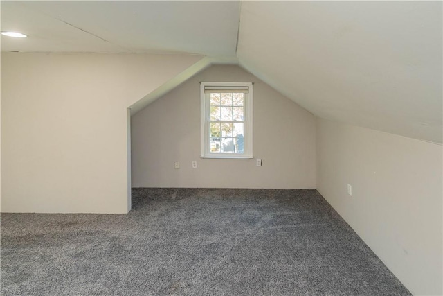 bonus room with carpet flooring and vaulted ceiling