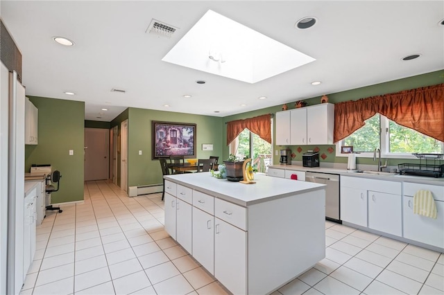 kitchen featuring dishwasher, a skylight, white cabinetry, and plenty of natural light