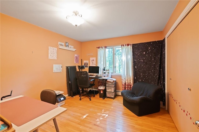 office space featuring light hardwood / wood-style floors and a baseboard heating unit