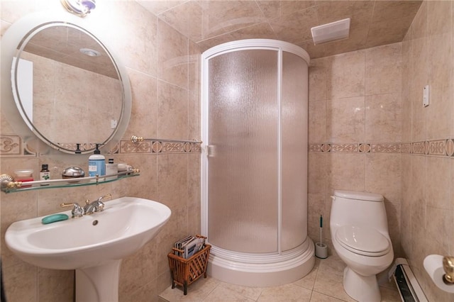 bathroom with tile patterned floors, a baseboard radiator, tile walls, toilet, and a shower with shower door