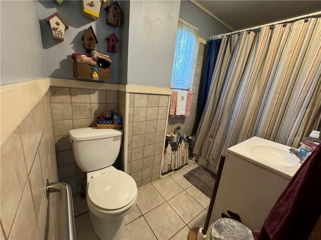 full bathroom featuring toilet, vanity, tile patterned floors, and tile walls