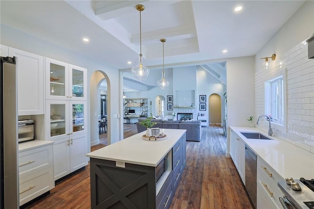 kitchen featuring appliances with stainless steel finishes, dark hardwood / wood-style flooring, sink, decorative light fixtures, and white cabinetry