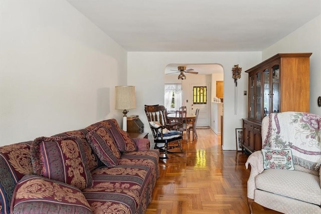 living room featuring ceiling fan and parquet floors