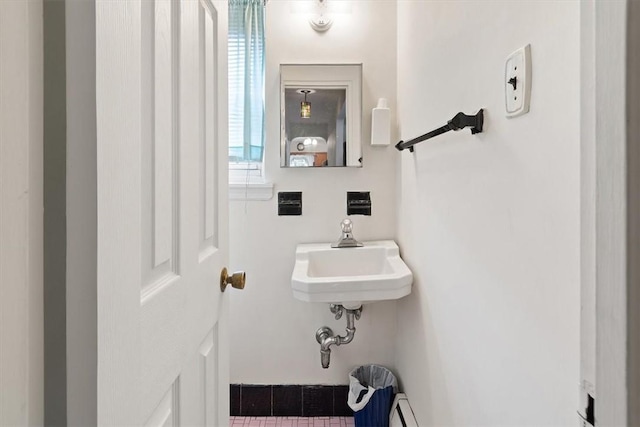 bathroom featuring sink and a baseboard heating unit