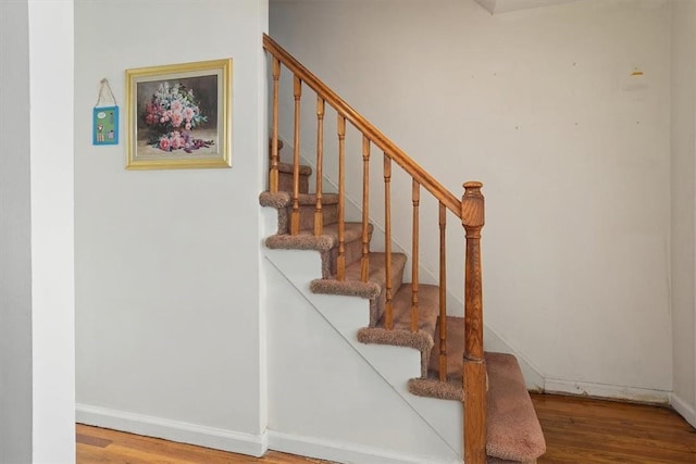 stairs featuring hardwood / wood-style floors