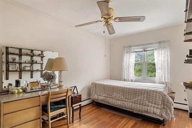 bedroom with ceiling fan, hardwood / wood-style floors, and a baseboard radiator