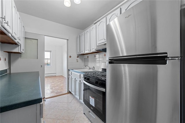 kitchen with appliances with stainless steel finishes, tasteful backsplash, sink, white cabinetry, and range hood