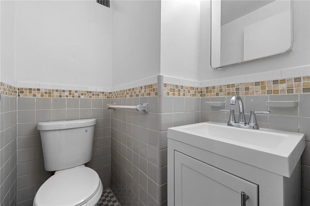 bathroom featuring vanity and tile walls