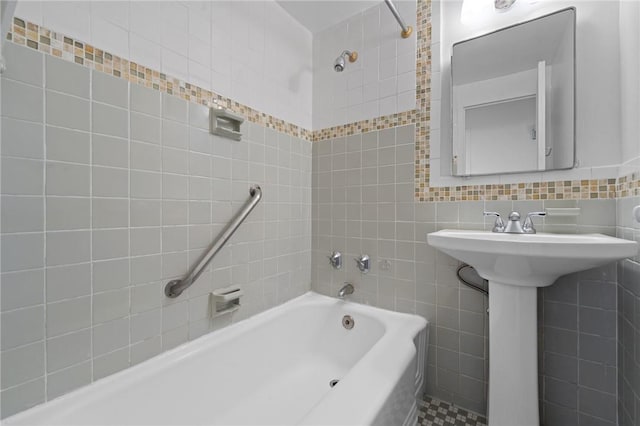 bathroom featuring tiled shower / bath and tile walls