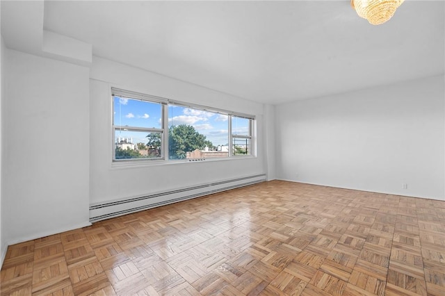 empty room with baseboard heating and light parquet floors