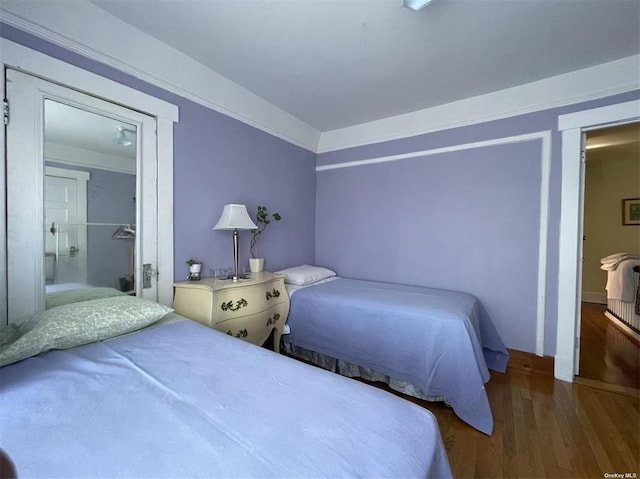 bedroom featuring a closet, wood-type flooring, and ornamental molding