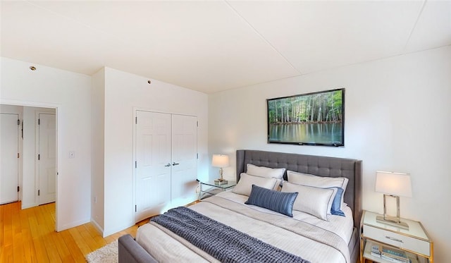 bedroom with light hardwood / wood-style flooring and a closet