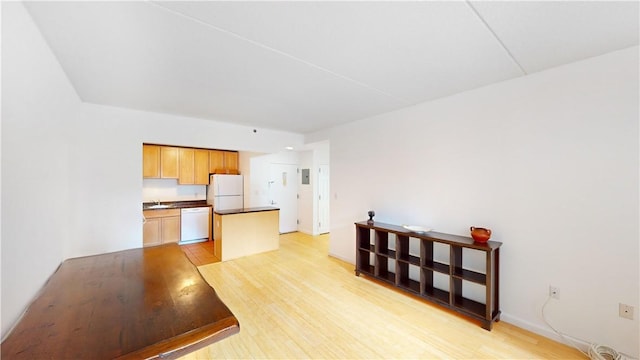 kitchen with light hardwood / wood-style floors, white appliances, and sink