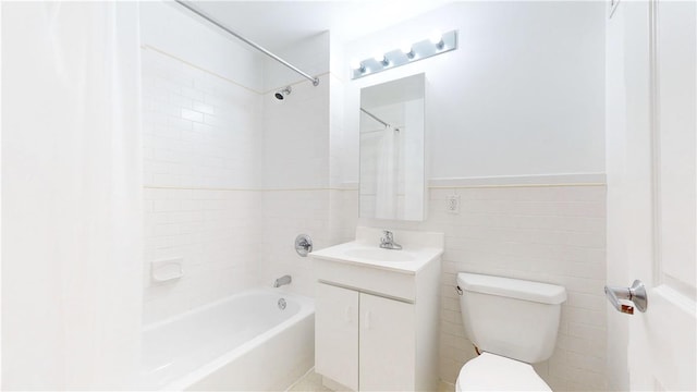 full bathroom with vanity, toilet, tile walls, and tiled shower / bath combo