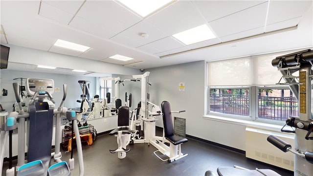 workout area featuring plenty of natural light and a drop ceiling