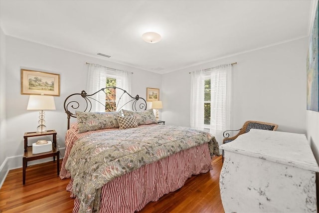 bedroom featuring hardwood / wood-style floors and multiple windows