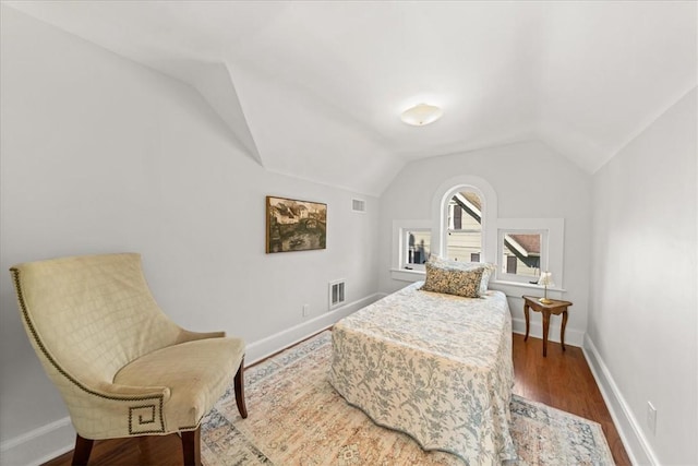 bedroom with hardwood / wood-style floors and lofted ceiling