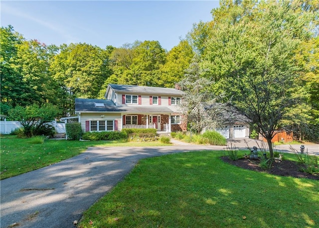 view of front of property with a porch, a garage, and a front yard