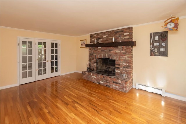 unfurnished living room with french doors, a brick fireplace, baseboard heating, crown molding, and hardwood / wood-style floors