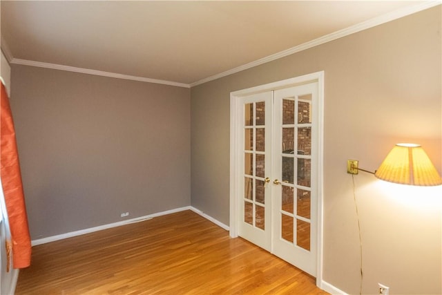 empty room with crown molding, french doors, and wood-type flooring