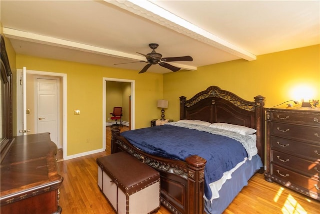 bedroom with ceiling fan, beamed ceiling, and light wood-type flooring