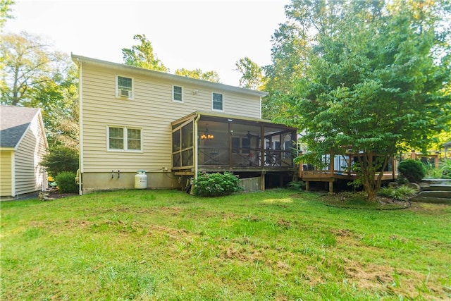 rear view of house with a lawn, a wooden deck, and a sunroom