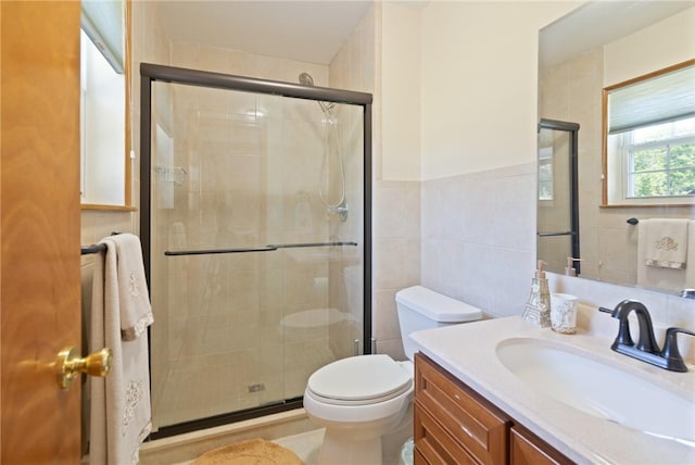 bathroom with vanity, an enclosed shower, tile walls, and toilet