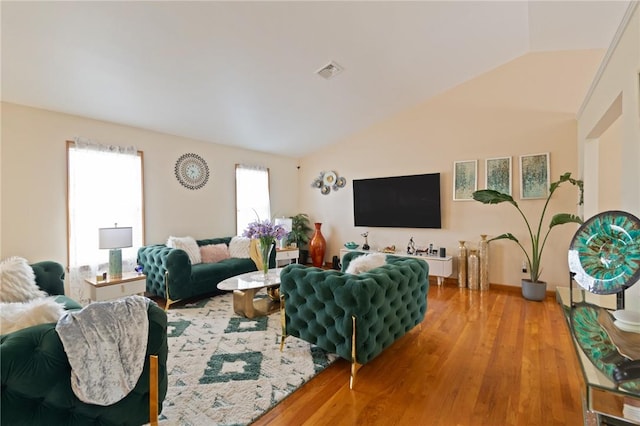 living room featuring light hardwood / wood-style floors and vaulted ceiling